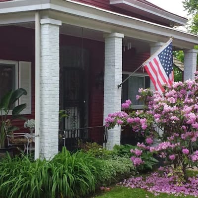Entrance of a personal care home with flowers and American flag