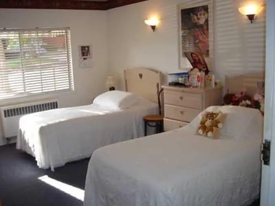 A shared resident room with two beds and furniture