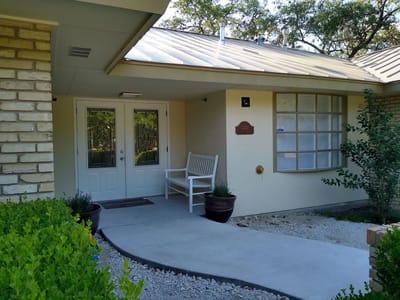 Entrance of Red Oak Memory Care with bench and plants