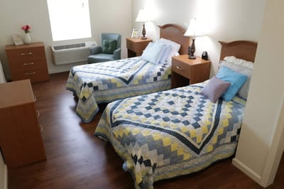 A cozy resident room with twin beds and natural lighting