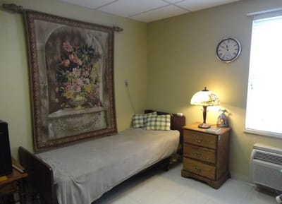 A private resident room with a bed and decorative wall art