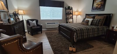 A cozy interior room with a bed and seating area