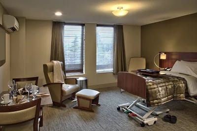 A well-furnished resident room with a bed and seating area