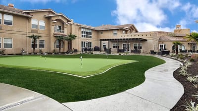 Outdoor garden area with putting green and building in the background
