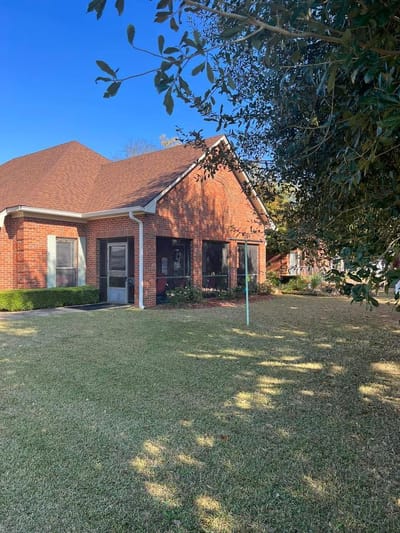 Exterior view of a brick building with a lawn