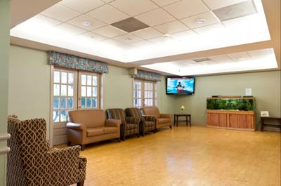Bright, spacious common area with seating and TV