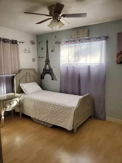Brightly decorated private resident room with a bed and window