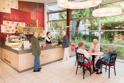 Residents and staff interacting in a dining area
