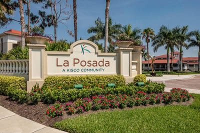 Exterior sign of La Posada with flowers and palm trees