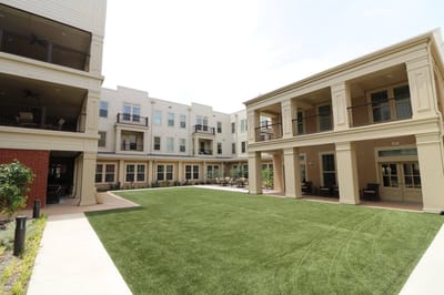 Outdoor area with landscaped green space and buildings