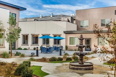 Outdoor seating area with a fountain and blue umbrellas