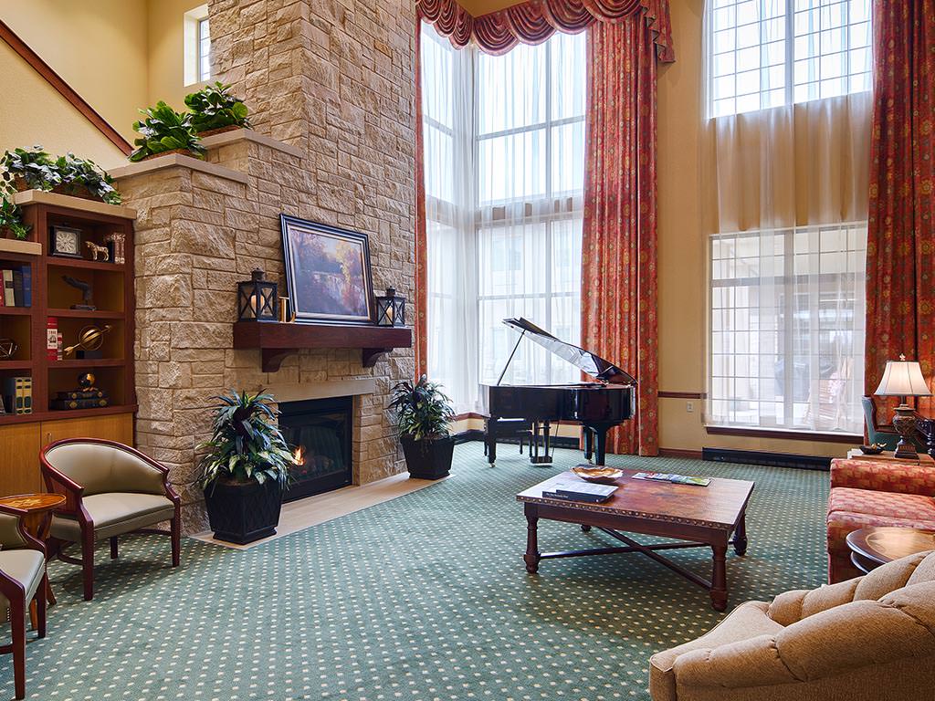 Bright interior common area with a fireplace and piano