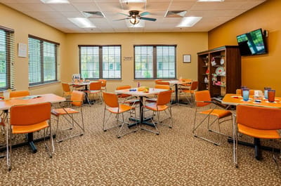 Bright dining area with orange chairs and tables