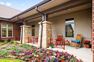 Porch area with rocking chairs and colorful flowers