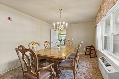 Dining room with a large wooden table and chandelier