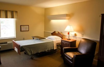 Cozy resident room with a bed and armchair