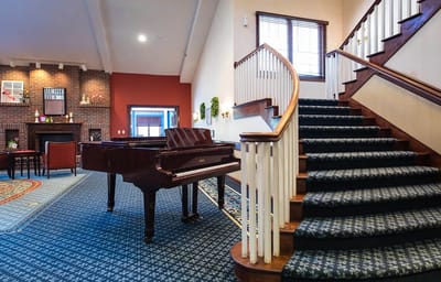 Interior view of a common area with piano and staircase