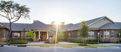Exterior view of a senior living facility with gardens