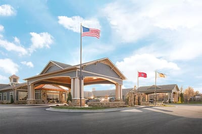 Exterior view of a senior living facility with flags