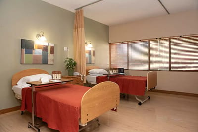 A shared resident room with two beds and a window