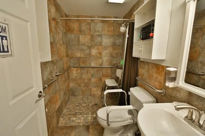 Accessible bathroom with grab bars and tiled walls