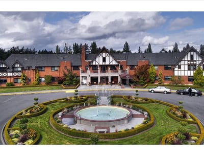 Aerial view of a senior living facility with gardens and fountain