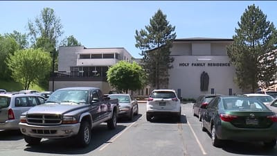 Exterior view of Holy Family Residence building with parked vehicles