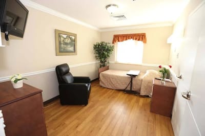 An interior view of a resident's room with a bed and chair