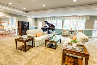 Bright common area with seating and a piano
