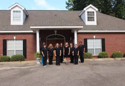 Staff members posing outside the facility entrance