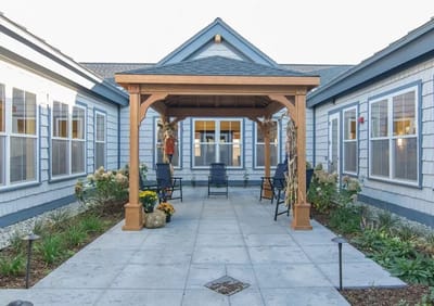 Covered patio area with seating and landscaping