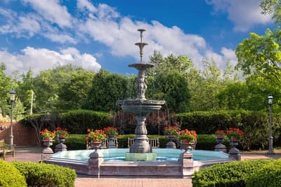 Outdoor fountain surrounded by greenery and flowers
