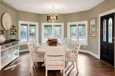 Bright dining area with large windows and a long table