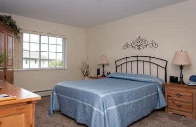 A cozy resident bedroom with a blue bedspread