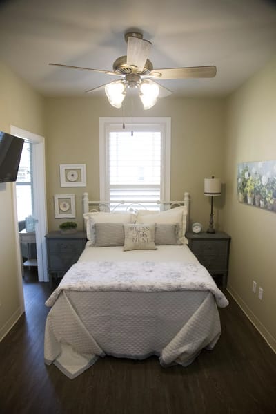 Cozy private resident room with a bed and lamp.