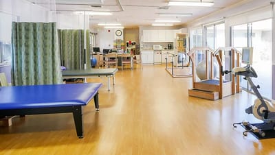 Physical therapy room with exercise equipment and spacious layout