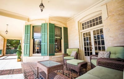 Outdoor seating area with green shutters