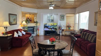 A cozy common area with red couches and a dining table