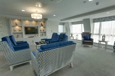 Common area with blue seating and a TV