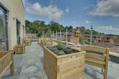 Outdoor patio area with wooden furniture and planters