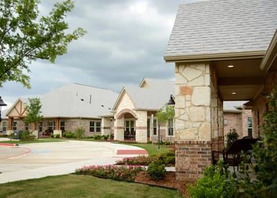 Outdoor view of a senior living facility with gardens