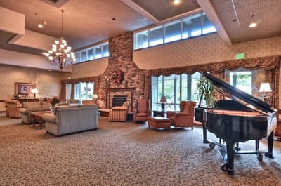 Narrows Glen, memory care in Tacoma, WA — Elegant lounge area with piano and fireplace