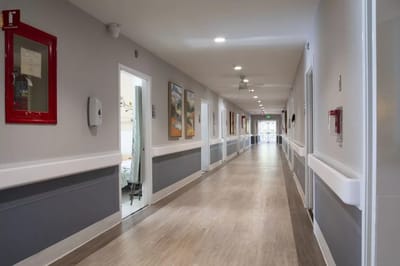 Brightly lit hallway with artwork and resident rooms