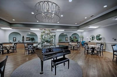 Bright dining area with a piano and tables