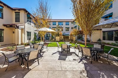 Outdoor courtyard with tables and chairs surrounded by buildings