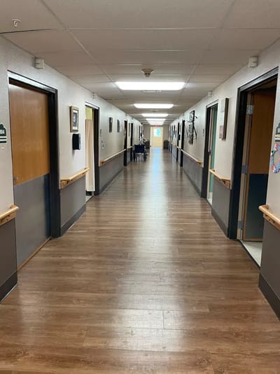 A hallway in a senior care facility with doors on both sides