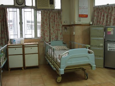 Interior view of a patient room with a hospital bed