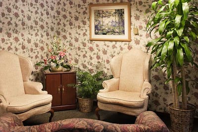 Cozy seating area with floral wallpaper and greenery