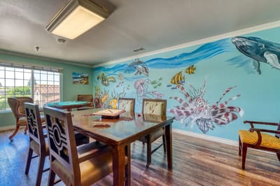 Artistic mural in a dining area with wooden tables
