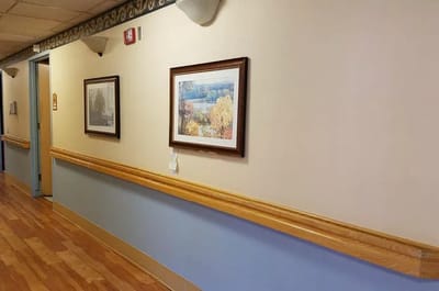 Interior hallway with paintings and wooden railing